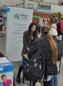 Zdjęcie przedstawia stoisko Wojewódzkiego Funduszu Ochrony Środowiska, a przy nim Doradca Energetyczny oraz młodzież szkolna