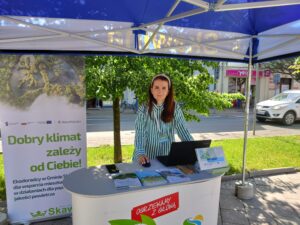 Doradca Energetyczny stoi na stoisku obok rollupa "Dobry klimat zależy od Ciebie" 