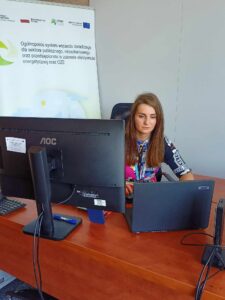 Zdjęcie prezentujące Doradcę Energetycznego (kobieta), siedzącego przed komputerem podczas webinarium i prezentującego slajdy na temat retencji.