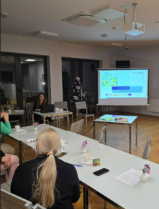 Zdjęcie przedstawia salę konferencyjną w której siedzą słuchacze spotkania oraz doradca energetyczny.