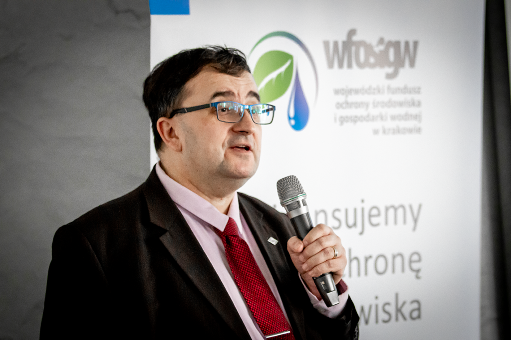 Obraz przedstawia sylwetkę Jerzego Popiela, prezesa zarządu Wojewódzkiego Funduszu Ochrony Środowiska i Gospodarki Wodnej w Krakowie, podczas spotkania szkoleniowego dla audytorów wykonujących prace w ramach zobowiązań nowej wersji programu Czyste Powietrze