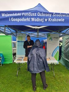 Zdjęcie przedstawiające Doradcę energetycznego udzielającego porad osobie w namiocie wystawienniczym