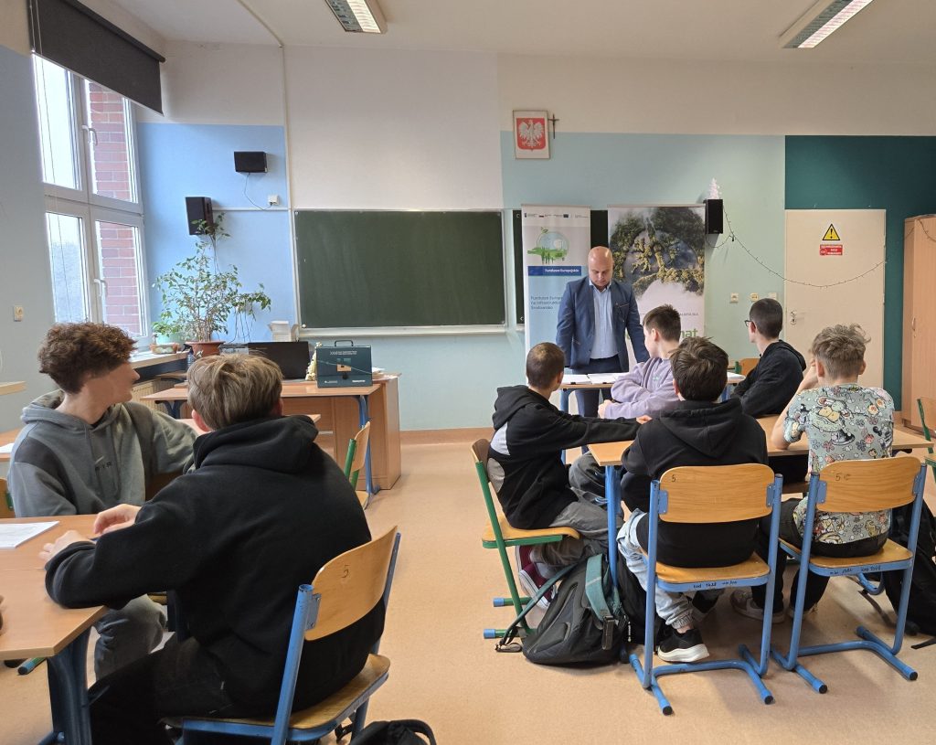 Zdjęcie przedstawiające uczniów siedzących w klasie i słuchających Doradcę Energetycznego